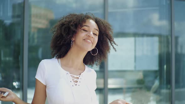 Happy Joyful Young Afro American Millennial Woman Enjoys Jumping High, Waving Arms and Dancing 