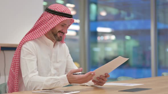 Arab Businessman Celebrating Success on Documents