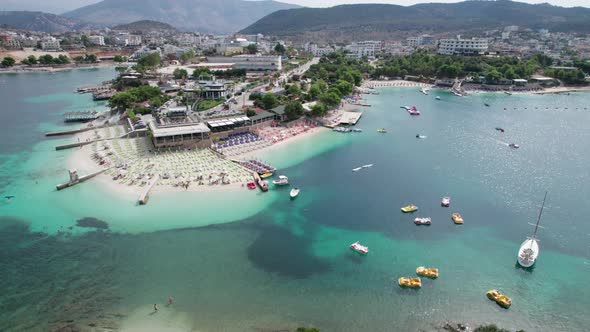 Aerial Azure Beach with Empty Sun Loungers and Boats Balkan Sea Coast Albania