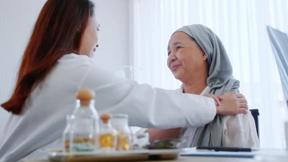 A specialist doctor is talking to an Asian elderly woman after recovering from cancer treatment.