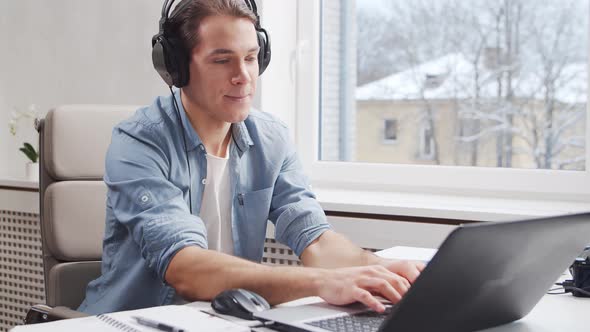 Workplace of freelance worker at home office. Young man works using computer.