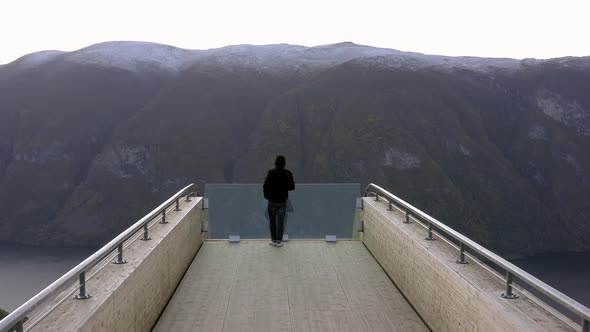 A Tourist Takes in the View from a Lookout Point in Norway