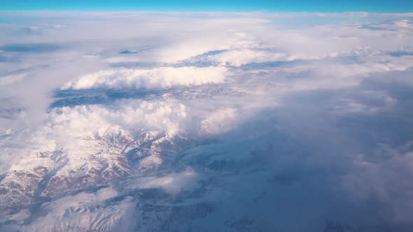 Airplane Flying Over Snowy Mountains