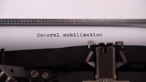 Typing phrase "General mobilization" on retro typewriter.