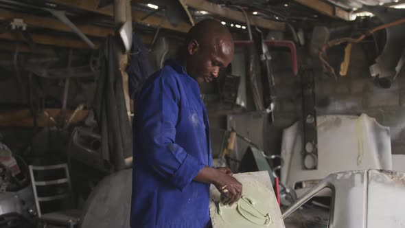 African man painting a car