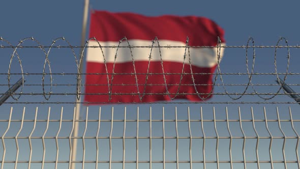 Waving Flag of Latvia Behind Barbed Wire