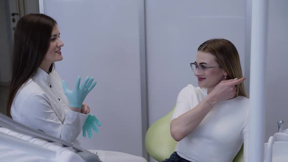 Happy Female Dentist Wearing Gloves During Professional Consultation in Clinic