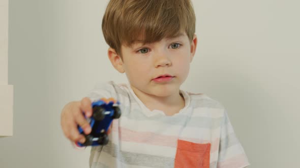 Little boy playing with a blue car