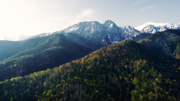 Aerial view of high mountains in summer or spring. Peaks are still covered with snow.