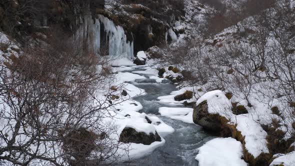 Snow Covered Valley With Rushing Water In Iceland During Winter 2