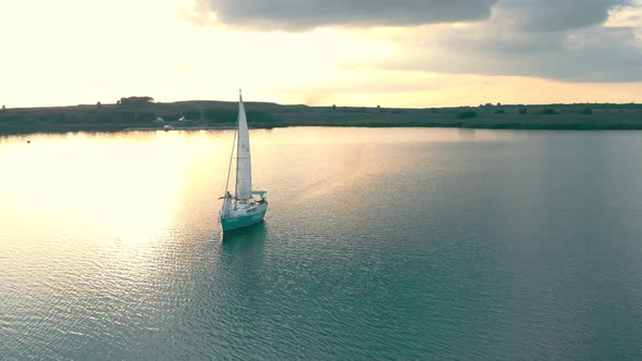 Aerial View One Yacht at Sunset in the Open Sea. Flight at Sunset Near the Yacht with a Sail View