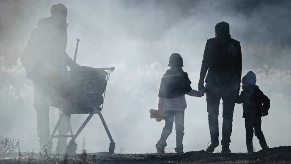 Back view of survivor family in gas mask going through clouds of toxic smoke and cinder