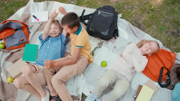 Schoolchildren Lying on Blankets in Park after School