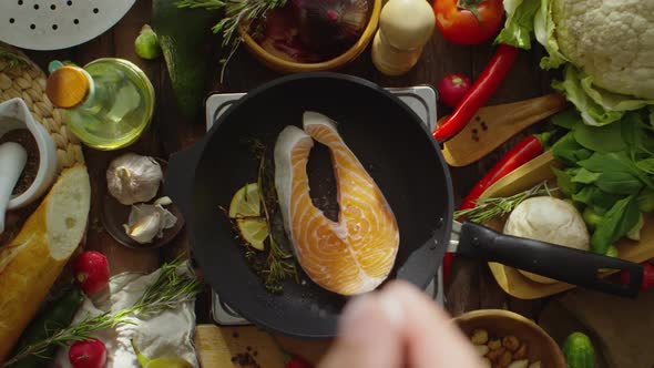 Adding Salt to Salmon on Frying Pan