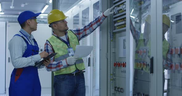 Two Electrical Workers Inspecting Equipment