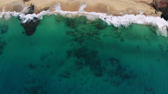 Aerial View Waves Break on White Sand Beach