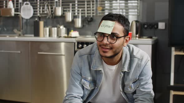 Young man playing sticker game with friends