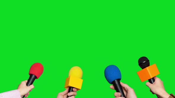 Microphones in the Hands of Journalists for Interview on Green Screen Background