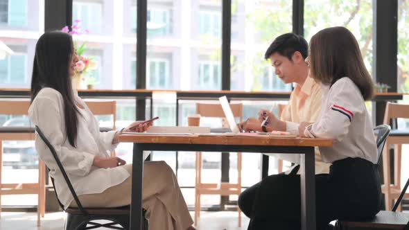 Young women and men chatting comfortably in a coffee shop.