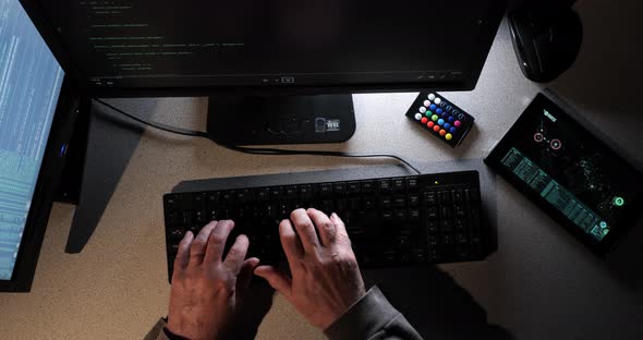 Hacker types as the overhead camera moves across their work area