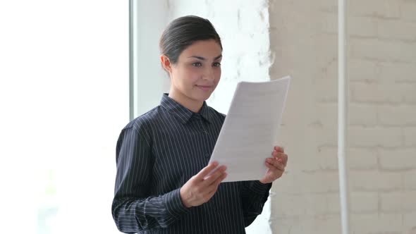 Indian Woman Standing and Reading Documents