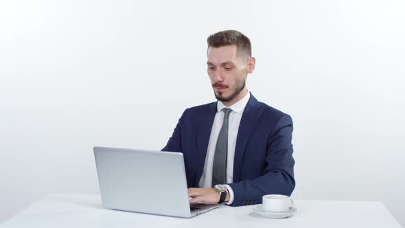 Businessman Working on Laptop and Drinking Coffee