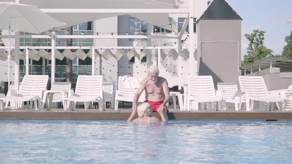 Happy Mature Couple Relaxing at the Pool in the Hotel Complex Together