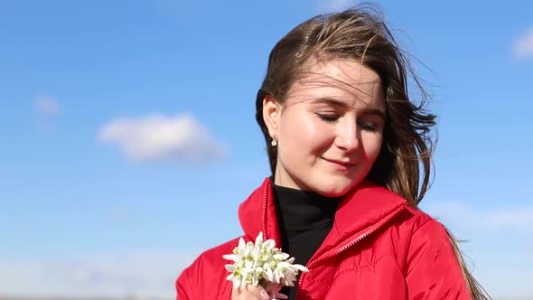 Beautiful Smiling Brunette Girl Holding Bouquet of Snowdrops First Spring Flowers.