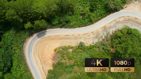 AH - Aerial View a Dirt Road Along Green Forest 11