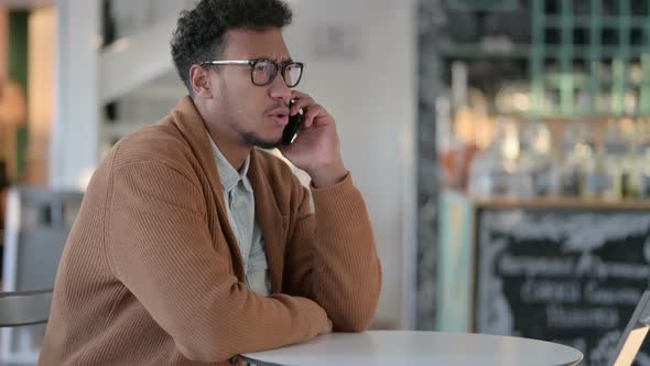 African Man Excited By Online Shopping Success on Smartphone