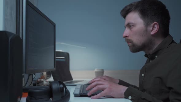 Computer Programmer Working at His Desk at Home