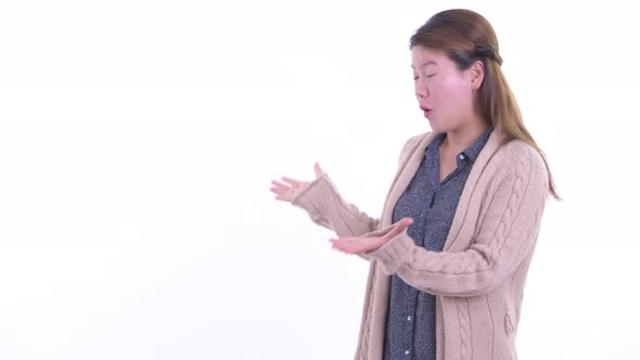 Happy Young Asian Woman Snapping Fingers and Looking Surprised Ready for Winter