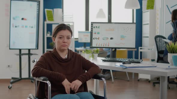 Young Invalid Woman Entrepreneur Sitting on Wheelchair Looking at Camera