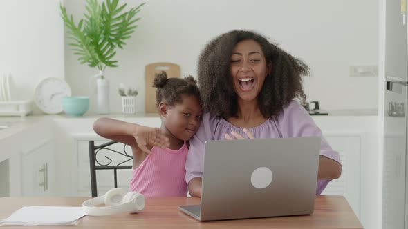 Multiethnic Family of Two Mom and Daughter Waving with Hands to the Interlocutor Looking at Webcam