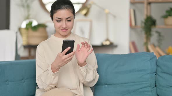 Indian Woman Using Smartphone on Sofa 