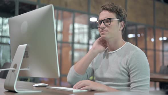 Tired Guy Having Neck Pain While Working on Desktop