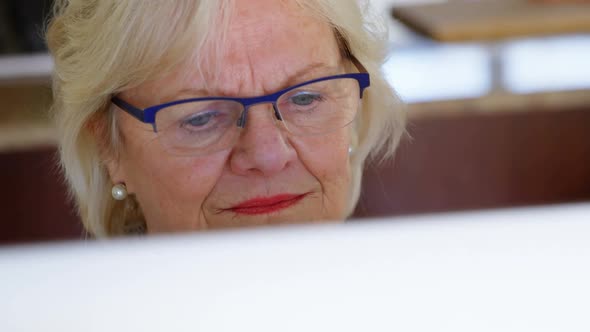 Senior woman using computer at home 4k