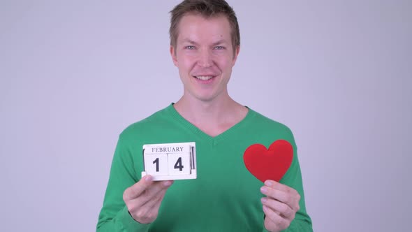 Happy Young Handsome Man with Calendar Block and Heart