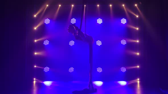 Female Aerial Equilibrium Gymnast Performing Balancing on a Air Silk in a Dark Studio