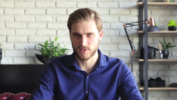 Confident businessman talking to camera making video conference from home during self isolation. Job