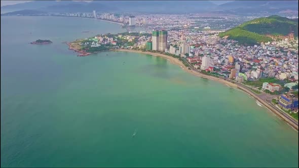 Drone Flies From Modern Resort City on Azure Ocean Shore