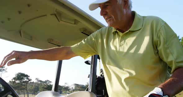 Golfer driving in his golf buggy