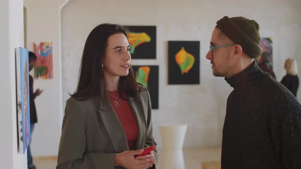 Man and Woman Posing for Camera in Art Gallery