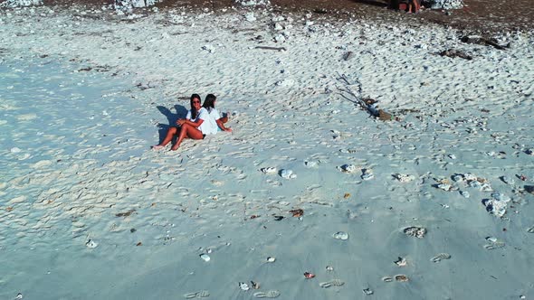 Sexy happy ladies travelling enjoying life on the beach on summer white sand and blue background 4K