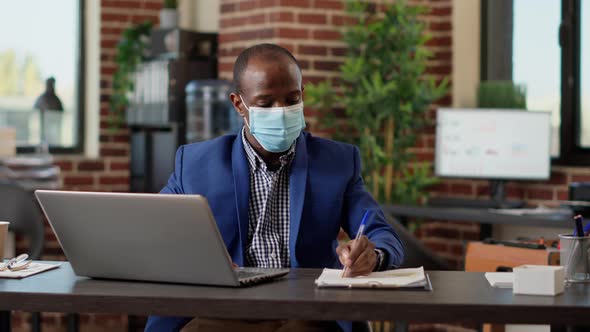 African American Worker Planning Business Statistics on Papers