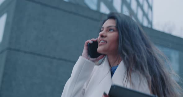 Young indian woman feeling happy during phone call