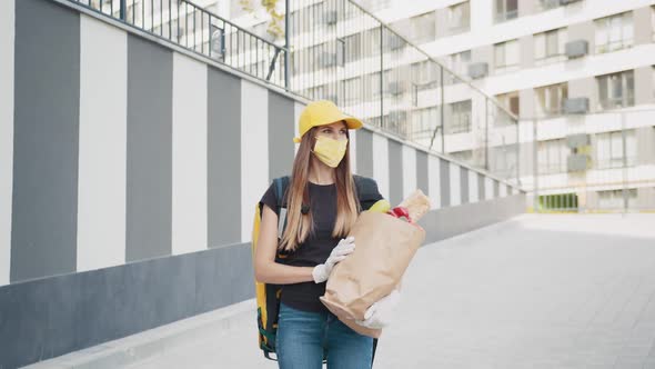 Portret Girl Delivery Worker in Gloves Cap and Medical Mask Walking the Street