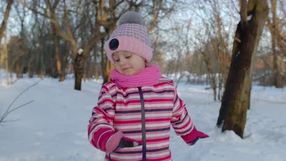 Smiling Child Kid Walking Having Fun Relaxing Looking Around on Snowy Road in Winter Park Forest