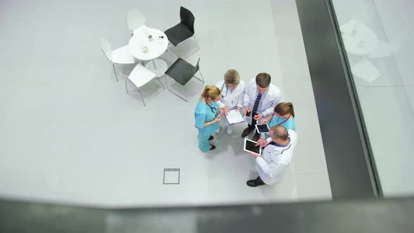 Team of doctors interacting with each other in corridor