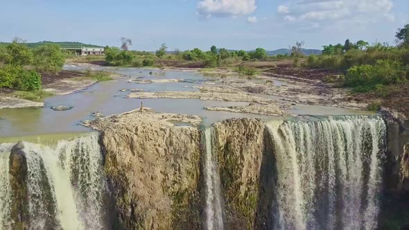 Flycam Shows Waterfall Streaming Among Rocks Against Sky